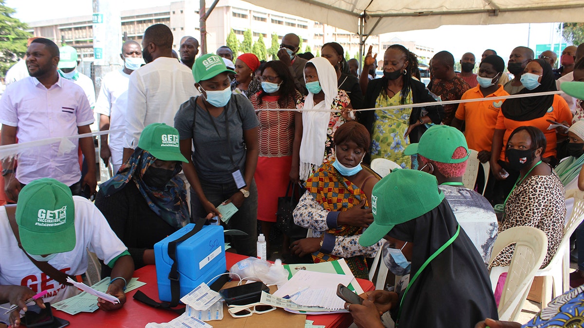 Nigeria civil servants wait to receive an AstraZeneca vaccine, in Abuja, Nigeria, Wednesday, Dec. 1, 2021. 