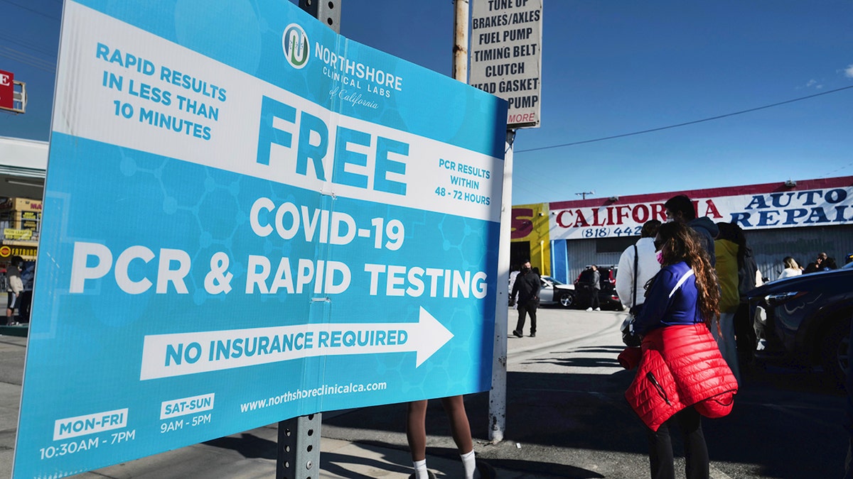 People line up for a free COVID-19 rapid test at a gas station in the Reseda section of Los Angeles on Sunday, Dec. 26, 2021, as California braces for a post-holiday virus surge.
