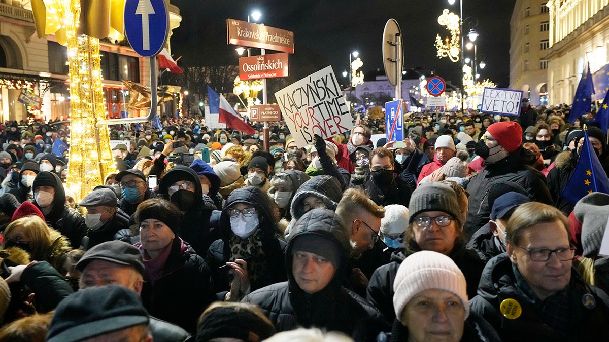 People demonstrate after the Polish parliament approved a bill that is widely viewed as an attack on media freedom, in Warsaw, Poland, Sunday Dec. 19, 2021.