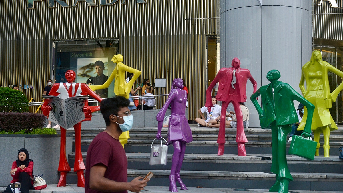 People wearing protective face masks walk along the Orchard Road shopping area in Singapore on Nov. 28, 2021. 