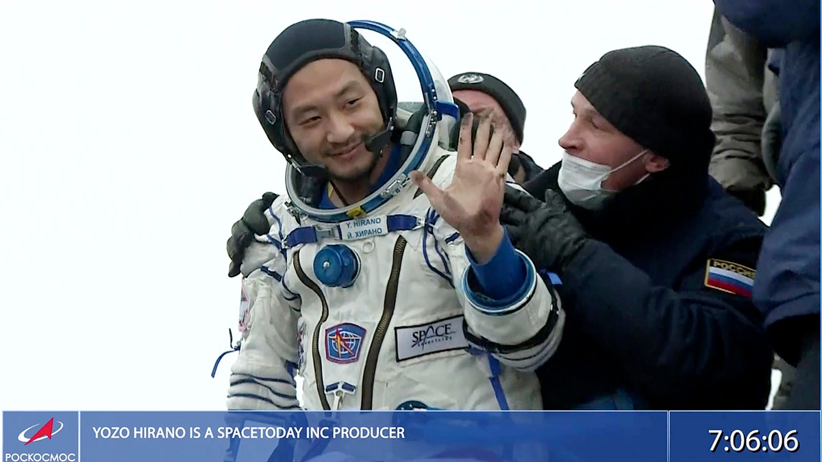 Yozo Hirano is helped from the capsule shortly after the landing in Kazakhstan, Monday, Dec. 20, 2021. 