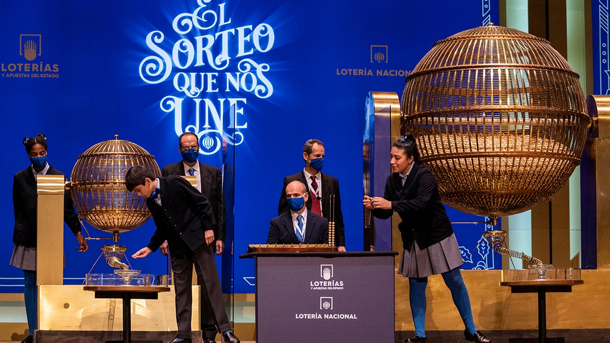 Children from Madrid's San Ildefonso school sing out awarded lottery balls at Madrid's Teatro Real opera house during Spain's bumper Christmas lottery draw known as El Gordo, or The Fat One, in Madrid, Spain, Wednesday, Dec. 22, 2021. 