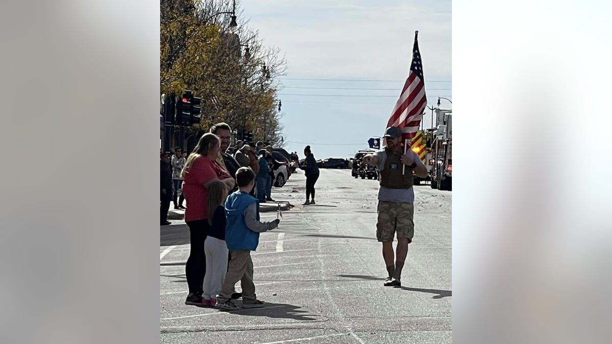 Derek Redenius, The Walking Patriot, walks by a waving crowd. (Derek Redenius)