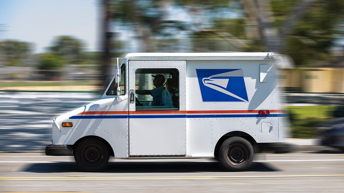 A USPS mail truck leaves for a delivery.