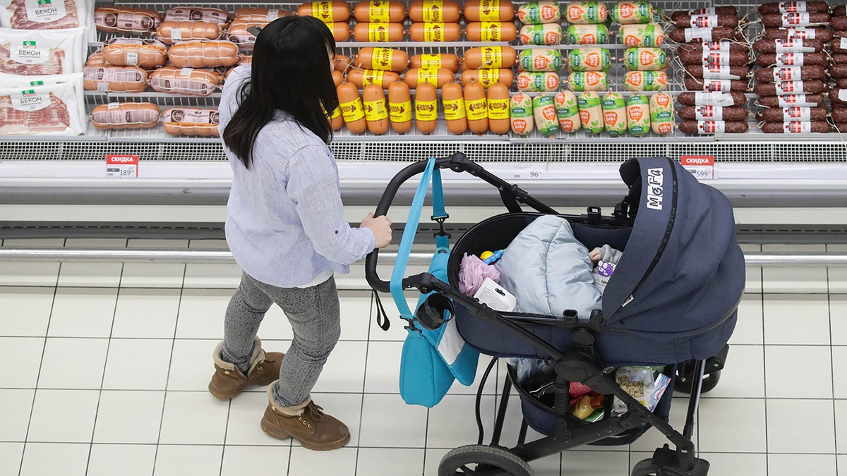  A woman shops for meat products at an Auchan hypermarket. 