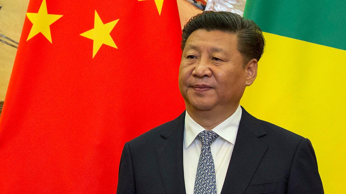 Chinese President Xi Jinping stands in front of national flags of China and Republic of Congo during a meeting with visiting Congolese dignitaries at the Great Hall of the People in Beijing, China, Tuesday, July 5, 2016.