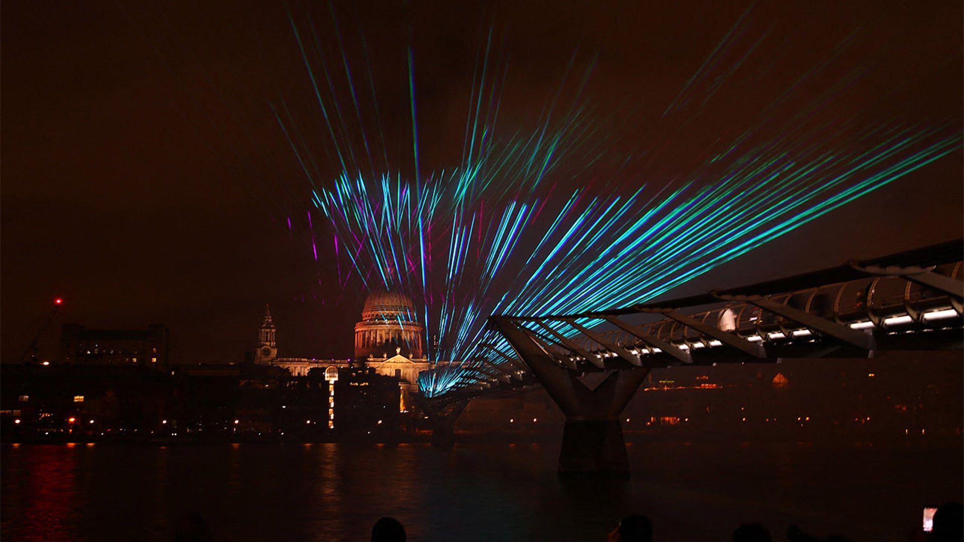 A laser display is pictured above the Millennium Bridge with St Paul's Cathedral seen behind, an alternative to the usual New Year's fireworks display, in central London just after midnight on January 1, 2022.