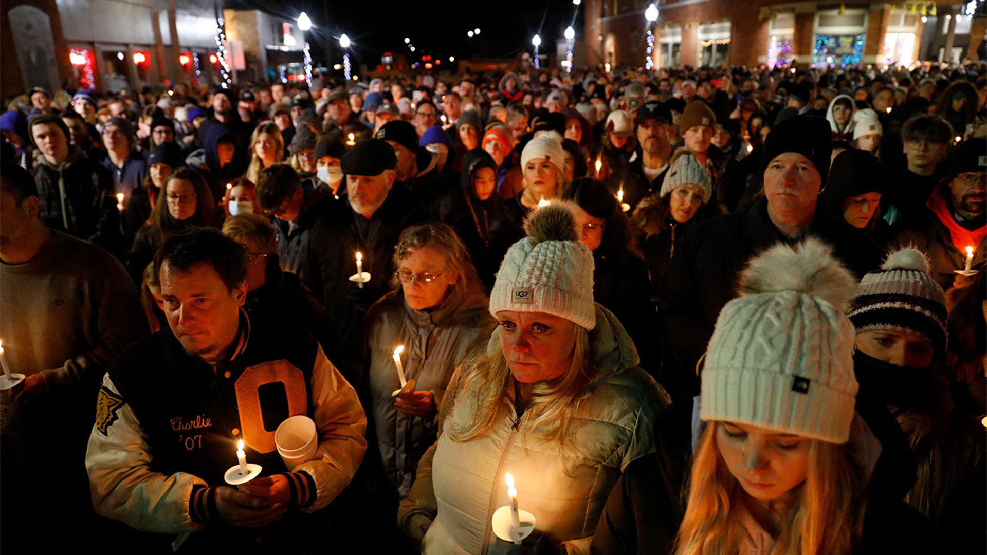 People gather for a candle light vigil for the victims of the Oxford High School shooting in downtown in Oxford, Michigan on December 3, 2021. - The parents of a 15-year-old boy who shot dead four students at a high school in the US state of Michigan with a gun bought for him by his father just days earlier were charged with involuntary manslaughter.