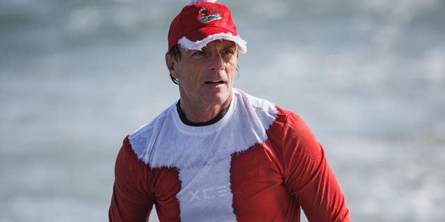 Surfing Santas hosted its 12th annual charity surf on Christmas Eve with a special appearance from former NFL quarterback Doug Flutie, who kicked off the event by jumping out a helicopter while wearing a Santa costume.