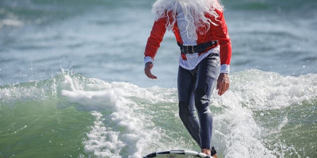 On Christmas Eve, more than 400 surfers and paddleboarders participated in the 12th annual Surfing Santas charity event in Cocoa Beach.