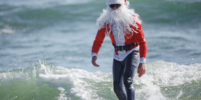 On Christmas Eve, more than 400 surfers and paddleboarders participated in the 12th annual Surfing Santas charity event in Cocoa Beach.