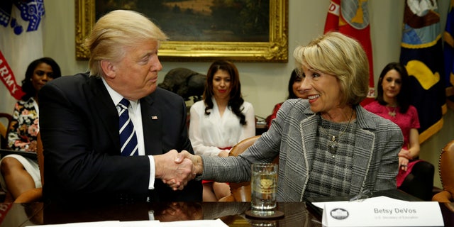 President Donald Trump congratulates Education Secretary Betsy DeVos on her confirmation at the White House on Feb. 14, 2017. REUTERS/Kevin Lamarque /File Photo