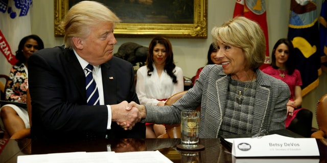 President Donald Trump congratulates Education Secretary Betsy DeVos on her confirmation at the White House on Feb. 14, 2017. REUTERS/Kevin Lamarque /File Photo