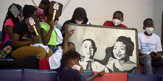 Children hold an illustration of Emmett Till and his mother, Mamie Till, during the launch of the Freedom Ride for Voting Rights Bus Tour on Juneteenth in Jackson, Mississippi, U.S. June 19, 2021. REUTERS/Eric J. Shelton