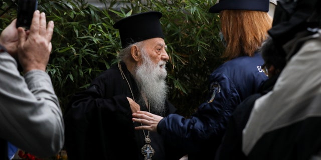 An Orthodox priest protests ahead of the arrival of Pope Francis, outside the Orthodox Archbishopric of Greece, in Athens, Greece, December 4, 2021. REUTERS/Louiza Vradi