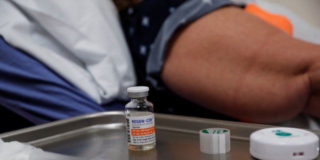 A vial of Regeneron monoclonal antibody sits on a medical table as registered nurse Jessica Krumwiede attempts to find a vein to administer it to Cathy Hardin at the Sarasota Memorial Urgent Care Center in Sarasota, 플로리다.