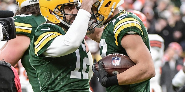 Green Bay Packers quarterback Aaron Rodgers (12) celebrates with wide receiver Allen Lazard (13) after setting the franchise record for most passing TDs in the first quarter during the game against the Cleveland Browns at Lambeau Field, Des. 25, 2021. 