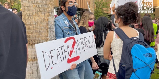 A protester holds a "Death to America" sign at a rally protesting Kyle Rittenhouse at Arizona State University.
