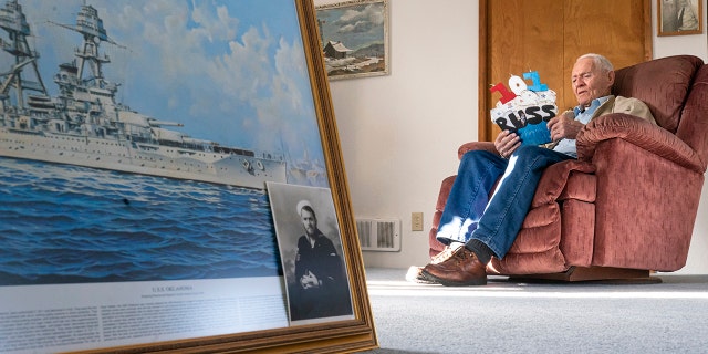 Pearl Harbor survivor and World War II Navy veteran David Russell, 101, reads a birthday card while talking about his time aboard the USS Oklahoma and his life after the war on Monday, Nov. 22, 2021, in Albany, Ore. (AP Photo/Nathan Howard)