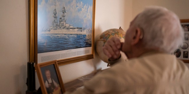 Pearl Harbor survivor and World War II Navy veteran David Russell, 101, looks at a painting of the USS Oklahoma while talking about the attack on Pearl Harbor on Monday, Nov. 22, 2021, in Albany, Ore. (AP Photo/Nathan Howard)