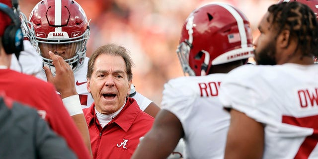 Alabama head coach Nick Saban talks with players in a time out during the first half of an NCAA college football game against Auburn Saturday, Nov. 27, 2021, in Auburn, Ala.