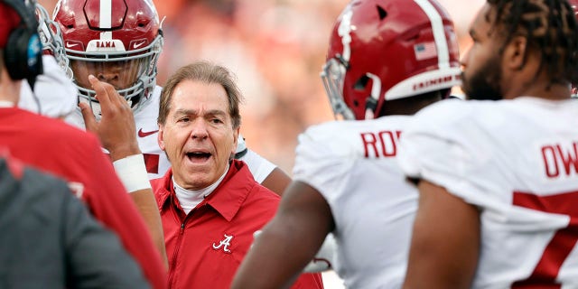 Alabama head coach Nick Saban talks with players in a time out during the first half of an NCAA college football game against Auburn Saturday, Nov. 27, 2021, in Auburn, Ala.