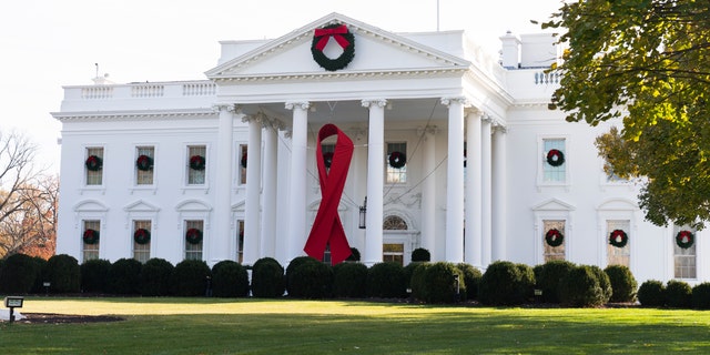 The North Portico of the White House is adorned with a huge red ribbon to commemorate the annual World AIDS Day, 수요일, 12 월. 1, 2021, 워싱턴. The Biden administration in its new HIV/AIDS strategy is calling racism "a public health threat" that must be fully recognized as the world looks to end the epidemic. (AP Photo/Manuel Balce Ceneta)