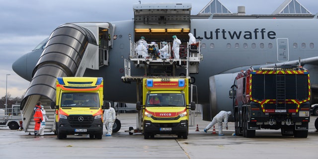 Un patient COVID-19 est transporté par le personnel médical de la Bundeswehr vers un avion A310 MedEvac de l'armée de l'air allemande à l'aéroport international de Dresde, en Allemagne, le mercredi 1er décembre 2021. (Robert Michael/dpa via AP)