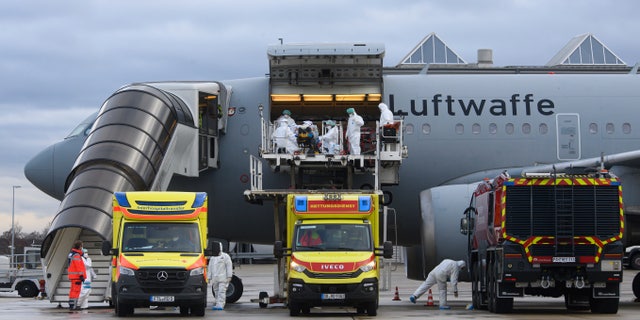 Un patient COVID-19 est transporté par le personnel médical de la Bundeswehr vers un avion A310 MedEvac de l'armée de l'air allemande à l'aéroport international de Dresde, en Allemagne, le mercredi 1er décembre 2021. (Robert Michael/dpa via AP)