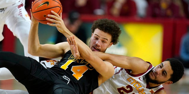 Iowa State wag Tristan Enaruna (23) probeer om die bal van die Arkansas-Pine Bluff-wag, Brahm Harris, te steel (14) gedurende die eerste helfte van 'n NCAA kollege basketbal wedstryd, Woensdag, Des. 1, 2021, in Ames, Iowa.