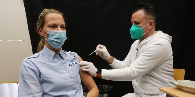 Une policière reçoit un rappel de vaccination contre le coronavirus et la maladie COVID-19 à Hilden, en Allemagne, le jeudi 2 décembre 2021. (David Young/dpa via AP)