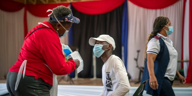 Um residente de Orange Farm, na África do Sul, escuta uma enfermeira após receber sua injeção contra COVID-19 na sexta-feira, 3 de dezembro de 2021, no centro polivalente de Orange Farm. A África do Sul acelerou sua campanha de vacinação uma semana após a descoberta da variante omicron do coronavírus. (AP Photo / Jerome Delay)
