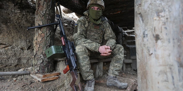 Ukrainian soldiers sits in a fighting position on the line of separation from pro-Russian rebels near Debaltsevo, Donetsk region, Ukraine, Ukraine Friday, Dec 3, 2021. In this Friday, the Ukrainian defense minister warned that Russia could invade his country next month. Russia-West tensions escalated recently with Ukraine and its Western backers becoming increasingly concerned that a Russian troop buildup near the Ukrainian border could signal Moscow's intention to invade. (AP Photo/Andriy Dubchak)