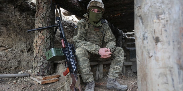 Ukrainian soldiers sits in a fighting position on the line of separation from pro-Russian rebels near Debaltsevo, Donetsk region, Ukraine, Ukraine Friday, Dec 3, 2021. In this Friday, the Ukrainian defense minister warned that Russia could invade his country next month. Russia-West tensions escalated recently with Ukraine and its Western backers becoming increasingly concerned that a Russian troop buildup near the Ukrainian border could signal Moscow's intention to invade. (AP Photo/Andriy Dubchak)