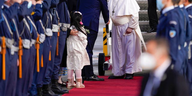 Pope Francis is greeted by Greek Foreign Minister Nikos Dendias as he arrives at the Eleftherios Venizelos International Airport in Athens, Greece, Saturday, Dec. 4, 2021.