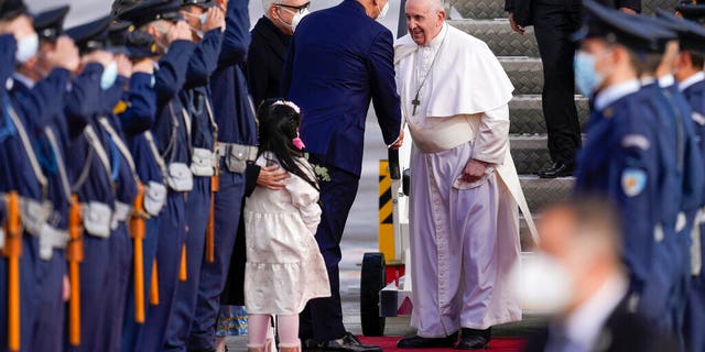 Pope Francis is greeted by Greek Foreign Minister Nikos Dendias as he arrives at the Eleftherios Venizelos International Airport in Athens, Greece, Saturday, Dec. 4, 2021. 