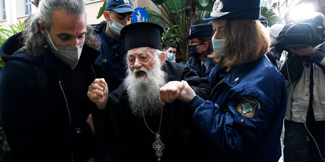 Police hold a protesting Orthodox Priest during the visit of Pope Francis at the Archbishopric of Greece in Athens, Saturday, Dec. 4, 2021. Pope Francis warned Saturday that the "easy answers" of populism and authoritarianism threaten democracy in Europe and called for fresh dedication to promoting the common good. (AP Photo/Michael Varaklas)