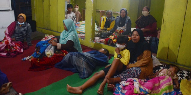 Villagers rest at a temporary shelter after evacuating their homes following the eruption of Mount Semeru in Lumajang, East Java, Indonesia, Saturday, Dec 4, 2021. The highest volcano on Indonesia's most densely populated island of Java spewed thick columns of ash high into the sky on Saturday, triggering panic among people living nearby. There were no immediate reports of casualties.(AP Photo/Hendra Permana)