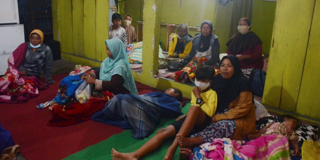 Villagers rest at a temporary shelter after evacuating their homes following the eruption of Mount Semeru in Lumajang, East Java, Indonesia, Saturday, Dec 4, 2021. The highest volcano on Indonesia's most densely populated island of Java spewed thick columns of ash high into the sky on Saturday, triggering panic among people living nearby. There were no immediate reports of casualties.(AP Photo/Hendra Permana)