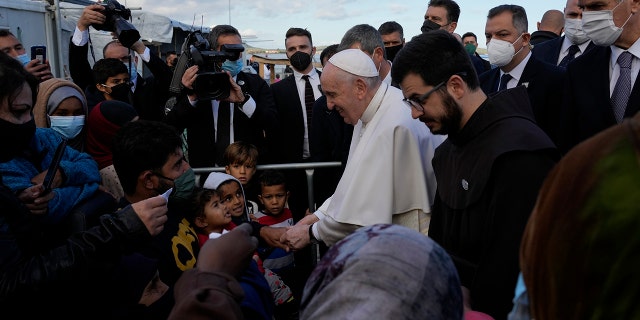 Pope Francis meets migrants during his visit at the Karatepe refugee camp, on the northeastern Aegean island of Lesbos, Greece, Sunday, Dec. 5, 2021. (AP Photo/Alessandra Tarantino)