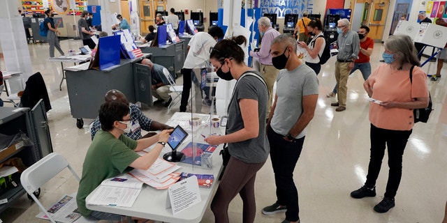 Voters sign in at Frank McCourt High School for New York's party primaries, June 22, 2021, in New York. (AP Photo/Richard Drew, File)