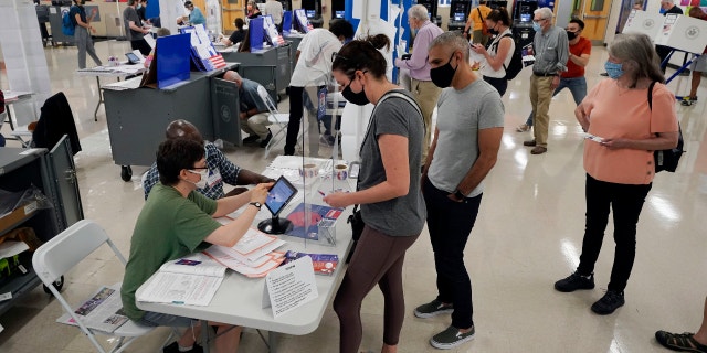 Voters sign in at Frank McCourt High School for New York's party primaries, June 22, 2021, in New York. New York City, long a beacon for immigrants, is on the cusp of becoming the largest city in the U.S. to give noncitizens the right to vote. (AP Photo/Richard Drew, File)