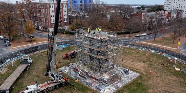 Workers begin the disassembly of the pedestal that once held the statue of Confederate General Robert E. Lee on Monument Avenue Wednesday Dec 8, 2021, in Richmond, Va. (AP Photo/Steve Helber)