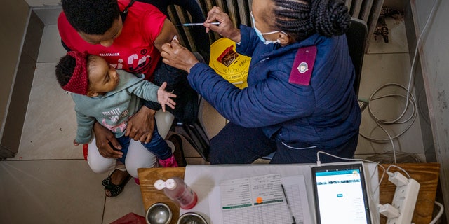 A woman is vaccinated against COVID-19 at the Hillbrow Clinic in Johannesburg, South Africa, Monday Dec. 6, 2021. The World Health Organization has appointed an independent scientific panel to advise on whether shots need reformulating because of omicron or any other mutant. (AP Photo/ Shiraaz Mohamed, File)