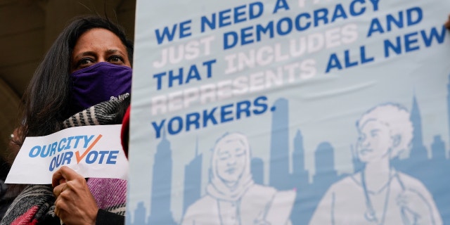 Activists participate in a rally on the steps of City Hall ahead of a New Yok City Council vote to allow lawful permanent residents to cast votes in elections to pick the mayor, City Council members and other municipal officeholders, Thursday, Dec. 9, 2021, in New York. (AP Photo/Mary Altaffer)
