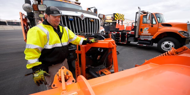 Chris Vigil prepares his snowplow for operation as forecasters predict the first snow of the season to sweep over Front Range communities Thursday, Dec. 9, 2021, at the Colorado Department of Transportation shed in Castle Rock, Colo. This winter more motorists may find themselves stuck on snowy highways or have their travel delayed due to a shortage of snowplow drivers — the latest fallout from a national labor shortage. As the snow begins to fall, states are having trouble finding enough people willing to take the comparatively low-paying jobs that require a Commercial Driver’s License and often entail working at odd hours in dangerous conditions. (AP Photo/David Zalubowski)