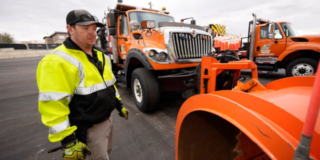 Chris Vigil prepares his snowplow for operation as forecasters predict the first snow of the season to sweep over Front Range communities Thursday, Dec. 9, 2021, at the Colorado Department of Transportation shed in Castle Rock, Colo. This winter more motorists may find themselves stuck on snowy highways or have their travel delayed due to a shortage of snowplow drivers — the latest fallout from a national labor shortage. As the snow begins to fall, states are having trouble finding enough people willing to take the comparatively low-paying jobs that require a Commercial Driver’s License and often entail working at odd hours in dangerous conditions. (AP Photo/David Zalubowski)