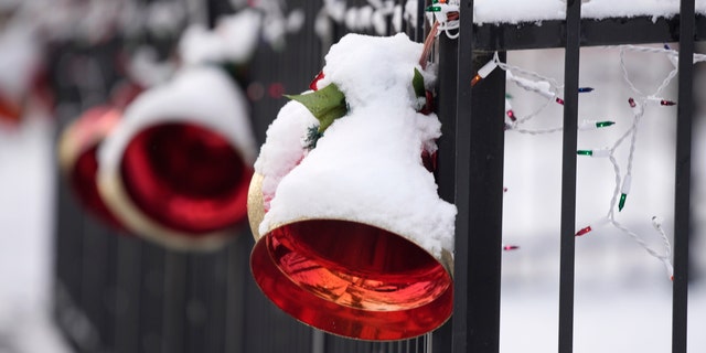 A light coating of snow covers holiday ornaments hung on the fence outside a home after a storm swept over the region and deposited the first snow of the season Friday, Dec. 10, 2021, in Denver. The snowfall was the first in 232 consecutive days in Denver, the second-longest snowless streak in city history only eclipsed by the mark of 235 days set in 1887. (AP Photo/David Zalubowski)