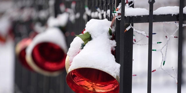 A light coating of snow covers holiday ornaments hung on the fence outside a home after a storm swept over the region and deposited the first snow of the season Friday, Dec. 10, 2021, in Denver. The snowfall was the first in 232 consecutive days in Denver, the second-longest snowless streak in city history only eclipsed by the mark of 235 days set in 1887. (AP Photo/David Zalubowski)