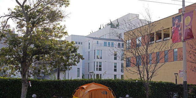 A tent is seen on a sidewalk just around the corner from the Opera House with a residential building in the background in San Francisco, Thursday, Dec. 2, 2021. (AP Photo/Eric Risberg)